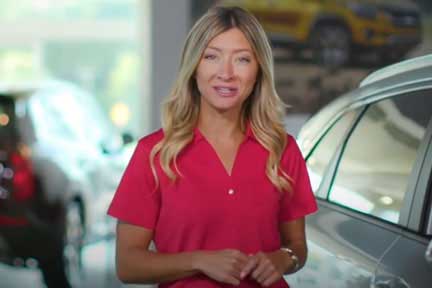 Young woman walking through car dealership